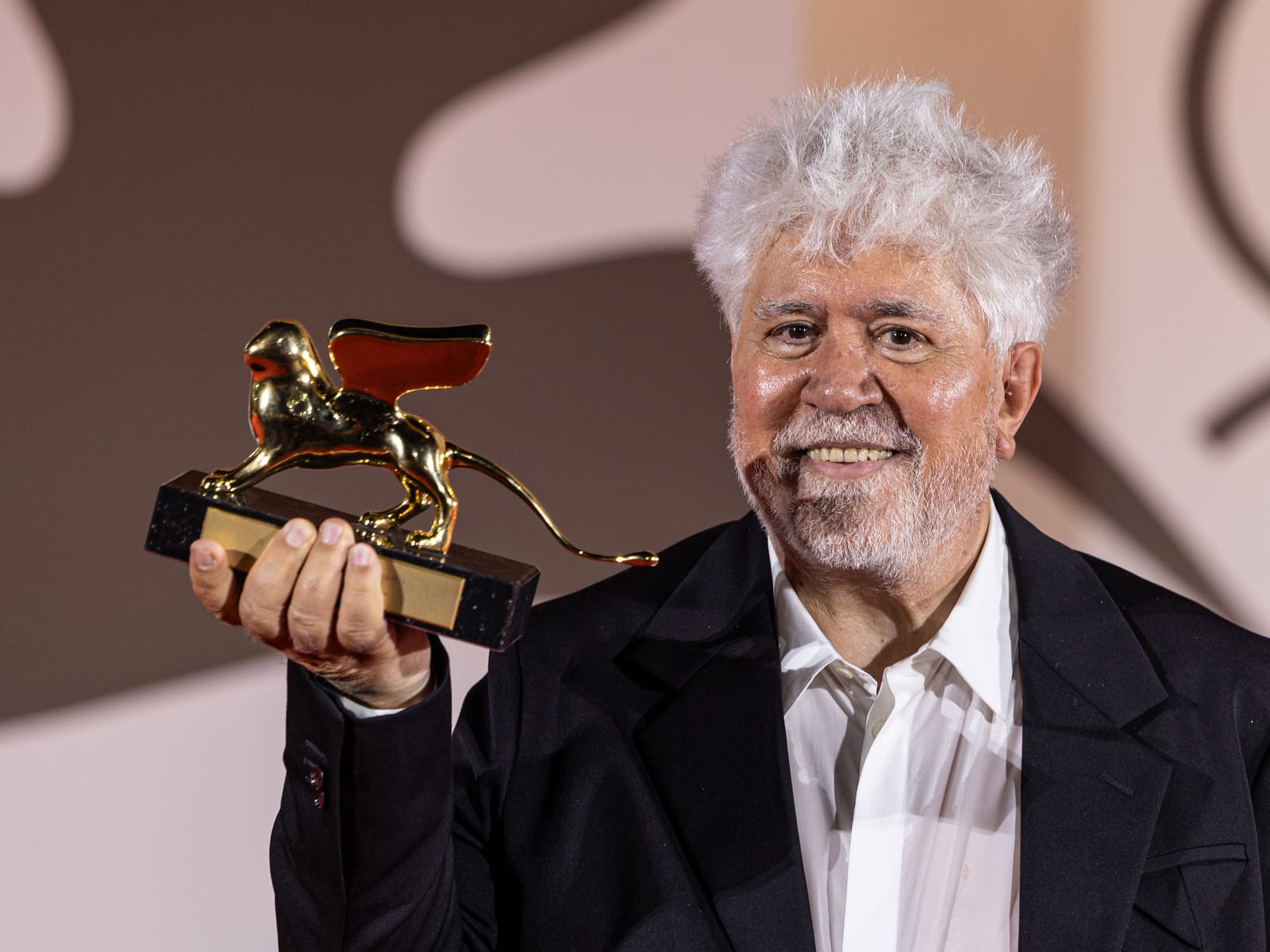 Pedro Almodóvar sonríe sosteniendo el León de Oro del Festival de Venecia.