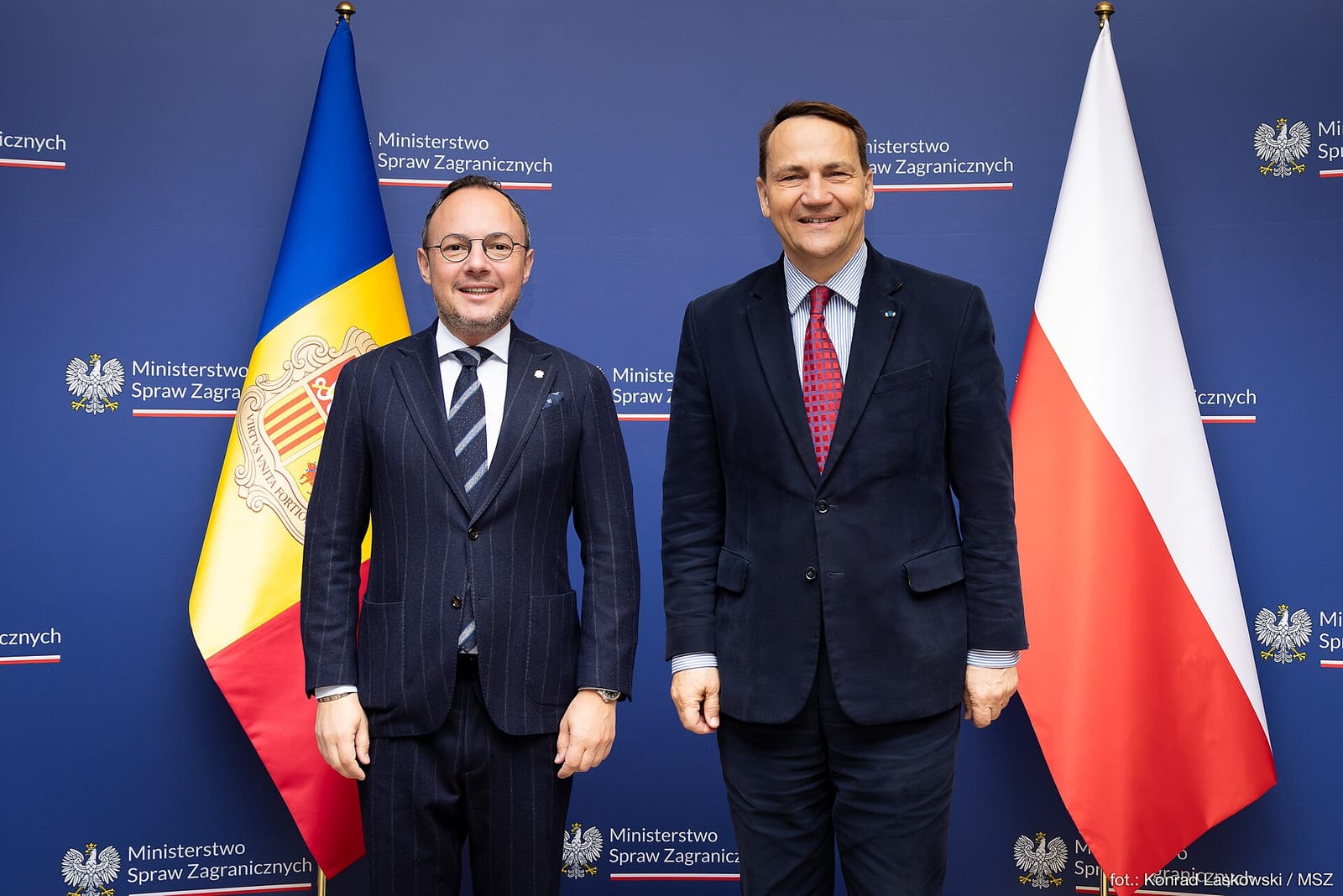 Xavier Espot y Radosław Sikorski posan ante banderas de Andorra y Polonia durante una reunión en Varsovia.