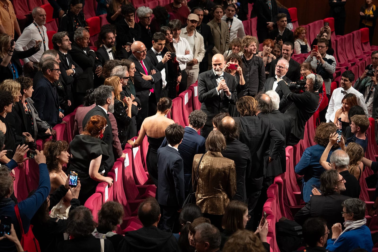 Tiago Guedes sostiene un micrófono ante el público durante la presentación de Aquí en Cannes en mayo de 2026.