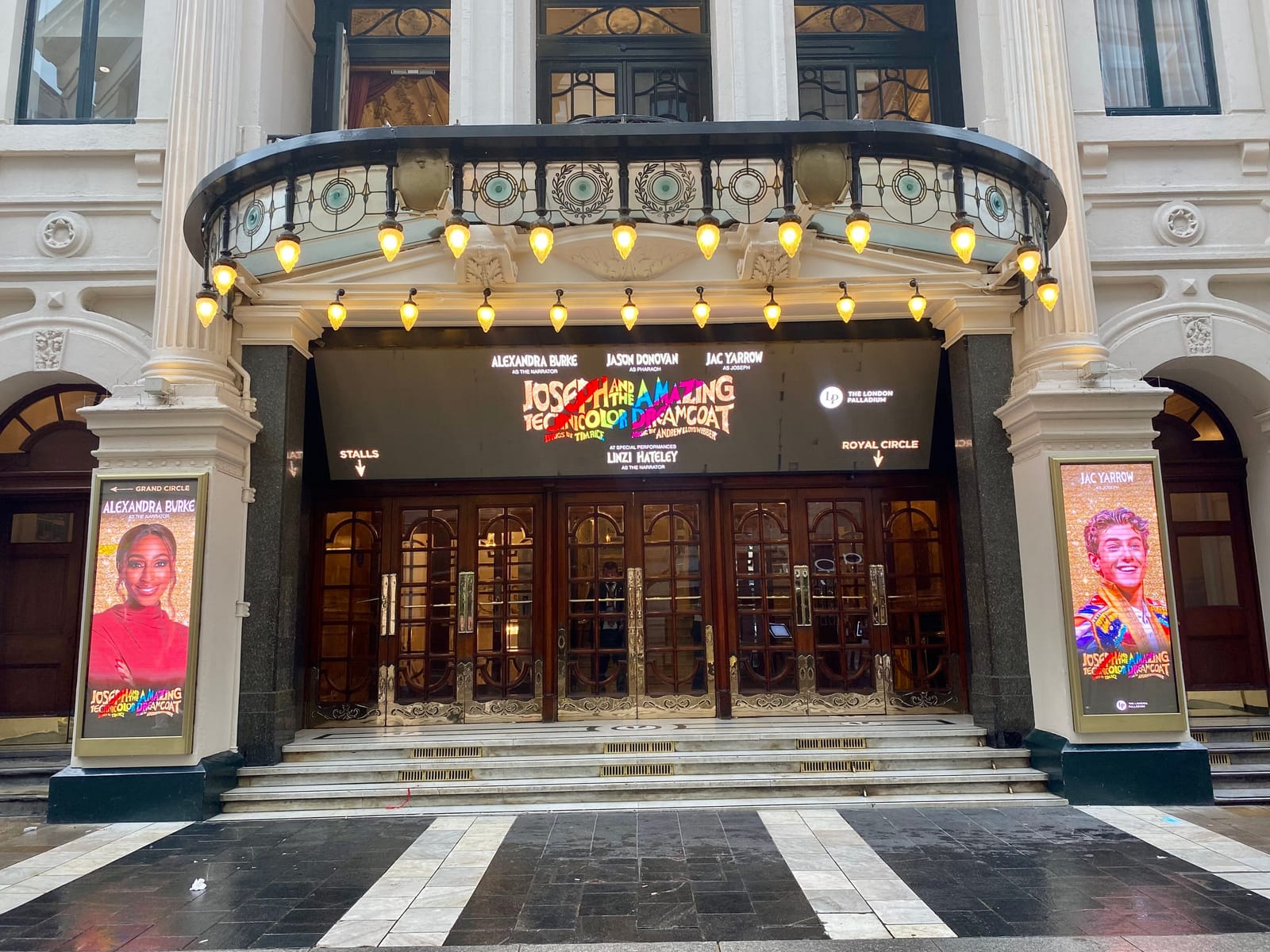 Entrada del teatro London Palladium, con su marquesina iluminada y carteles de espectáculos.