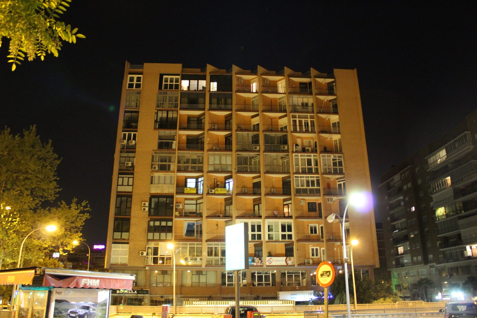 Edificio de viviendas de varias plantas en el paseo de la Castellana de Madrid, iluminado de noche.